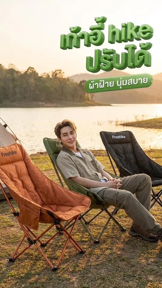 ชายนั่งเก้าอี้พับริมทะเลสาบ